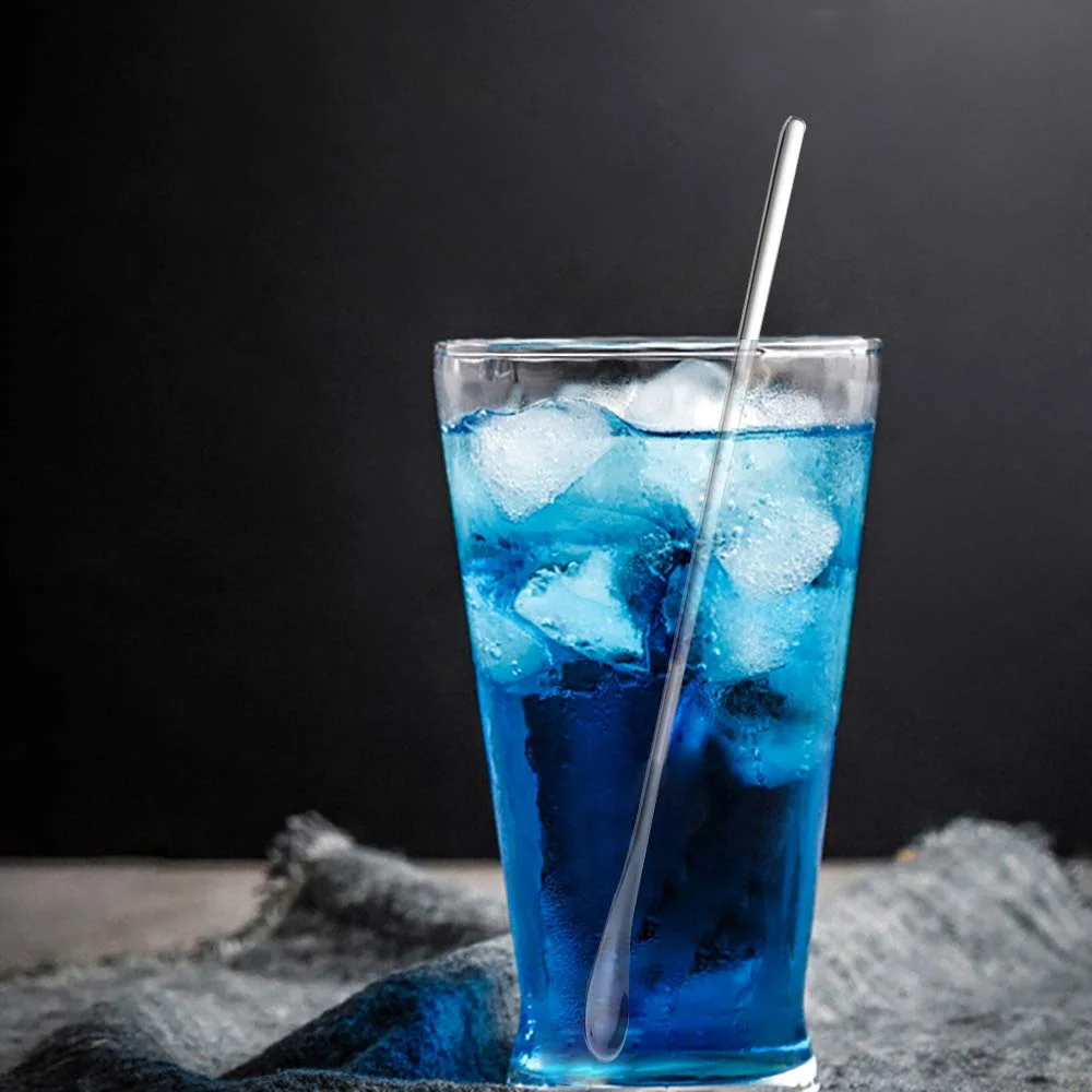 A Delove stirring spoon in a tall glass of blue soda, with ice.